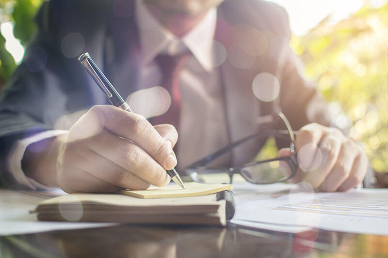 Individuelles Portfolio - Finanzielle Freiheit im Business Kontext - Älterer Herr im Anzug schreibt